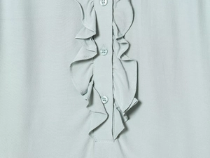 Detail of light blue ruffle collar top with triple button closure and fine fabric texture