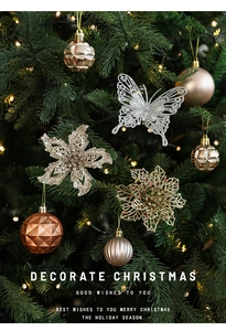 Gros plan de papillons et fleurs de Noël dorés et bronzes pailletés sur un sapin décoré