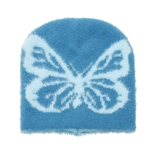 Dettaglio del berretto in maglia blu con texture in finta pelliccia e motivo a farfalla