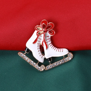 Détail de la broche patins à glace en émail blanc avec lacets rouges et cristaux brillants
