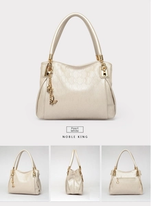 Detailed views of pearl white handbag with embossed oval texture and golden charms