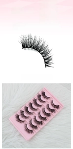 Detail showing 10 pairs of dense black false eyelashes with thin bands on pink tray