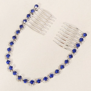 Detail of silver bridal hair comb with blue crystal chain on a neutral background