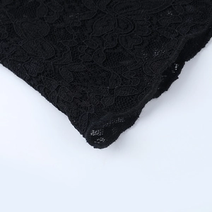 Close-up detail of delicate floral lace pattern on semi-transparent black fabric