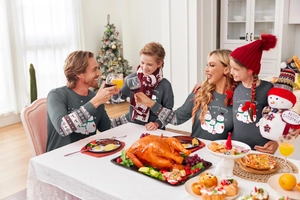 Close-up of gray Christmas family sweatshirt with snowman print and festive dining background