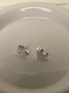 Detailed view of 925 sterling silver heart studs with textured liquid metal finish