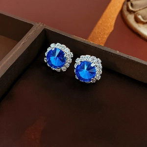 Macro shot of French luxury royal blue square stud earrings with shimmering white halo crystals