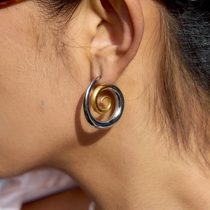 Elegant two-tone spiral thread earrings in gold and silver stainless steel on model