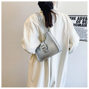 Detail of silver shoulder bag showing woven edge stitching and metal chain strap