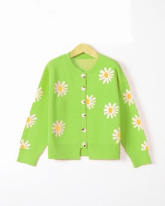 Detail shot of green knit cardigan featuring large white daisy embroidery and neat buttons