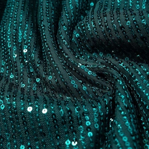 Detailed close-up of dark green sequin fabric showing shiny rows of textured sparkles