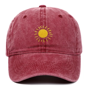 Detailed embroidery of yellow sun on a vintage washed burgundy cotton baseball cap