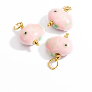 Detailed view of pink fish-shaped natural stone pendants with gold loops for DIY jewelry