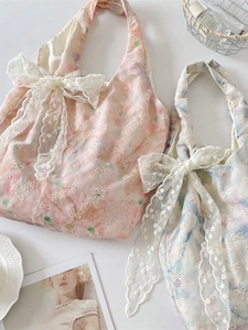 Floral watercolor tote bag with lace bow decoration and embroidery in a flat lay view