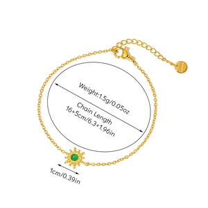 Detail of 18K gold plated steel bracelet with sunburst pendant and green stone inlay