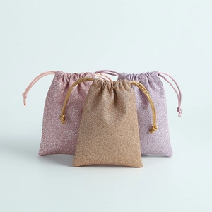 Three glittering velvet drawstring jewelry gift bags in pink gold and purple colors