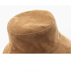 Detailed view of brown corduroy fabric texture and stitching on top of the bucket hat