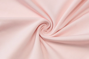 Close-up of pink knitted fabric showing detailed texture and soft pleated folds