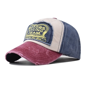Detail of vintage washed cotton baseball cap with distressed brim and motor racing patch