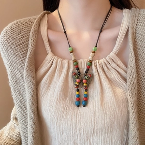 Close-up of bohemian butterfly pendant necklace with colorful beads on a wax cord strap