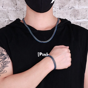 Close-up of blue and silver spliced cuban chain necklace and bracelet on a model