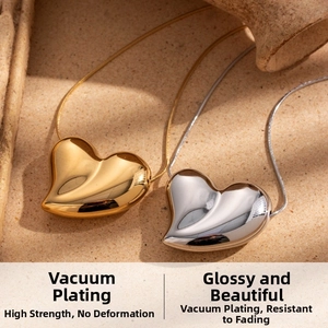 Detail of gold and silver heart pendants with mirror polished finish on sand background