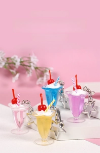 Close-up of dessert keychain charms featuring cream cups with star clips and mini spoons