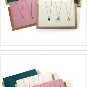 Detail of wooden display stand with pink, beige, and cyan velvet pads for jewelry