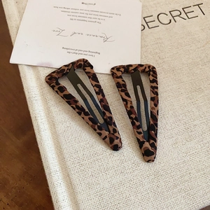 Dettaglio di fermagli per capelli BB triangolari leopardati su cartoncino vintage