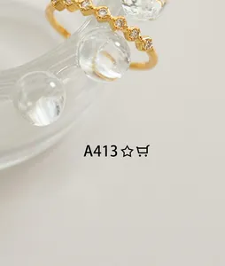 Macro detail of gold-plated beaded ring featuring sparkling white cubic zirconia stones