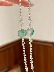 Dettaglio di orecchini a nappa in argento con calcedonio verde e zirconi luccicanti