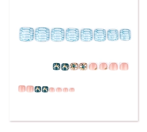 Detail of blue snake print and emerald gemstone press-on toenails with sparkling crystals