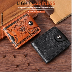 Detail of brown and black leather wallets with dollar pattern on wooden desk