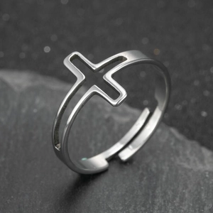 Silver hollow cross geometric open ring for women on a natural dark grey rock background