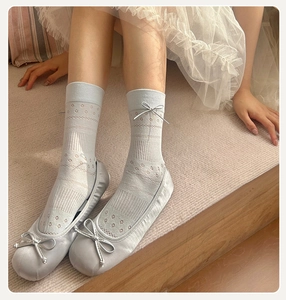 Details hellblauer Mesh-Socken mit Lederschleife kombiniert mit Satin-Ballerinas
