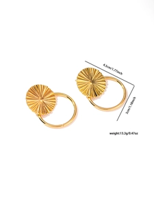 Macro shot of gold geometric earrings showing fan-textured disks and smooth metal rings