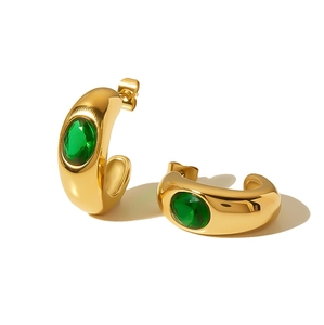 Detailed view of C-shaped 18K gold plated earrings with inlaid green zircon stones