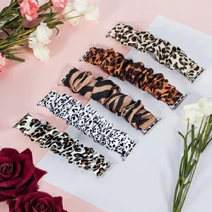Five assorted animal print scrunchie watch bands for Apple Watch displayed on pink background