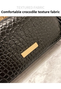 Macro shot of black crocodile embossed fabric with golden metal clasp on gray marble