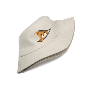 Close-up of beige canvas bucket hat featuring creative cartoon bear zipper print details