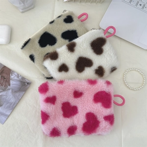 Detailed close-up of fluffy heart-patterned plush pouches in three soft colorways