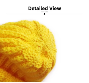 Close-up of bright yellow chunky knit beanie showing detailed top stitching texture