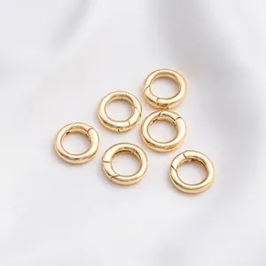 Detailansicht von sechs 14K goldgefüllten Federringverschlüssen für DIY-Schmuck auf Seide
