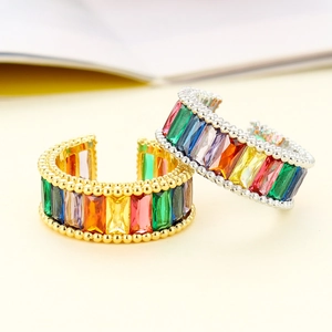 Macro detail of gold and silver open rings with rainbow baguette zirconia and beaded edges