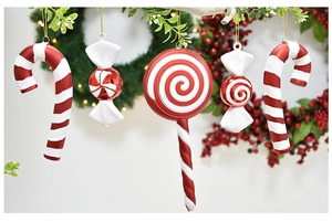 Macro view of red and white Christmas candy cane ornaments with gold hanging strings