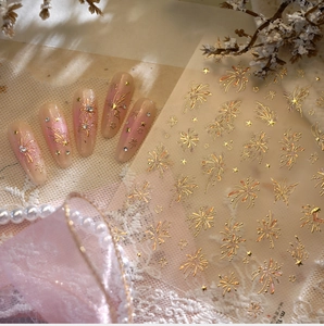 Macro shot of 3D embossed gold fireworks nail stickers with pink gradient almond nails