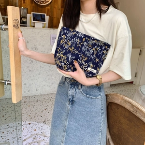Navy blue floral makeup pouch with exquisite embroidery detail and brand woven label