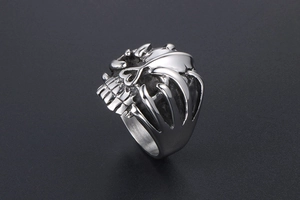 Detail of vintage punk skull ring with silver skeletal hand grip in cast titanium steel