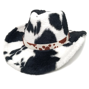 Détail d'un chapeau de cow-boy en peluche à motif vache avec un ruban décoratif beige