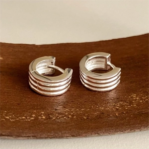 Close-up of 925 sterling silver hoop earrings with a four-layer textured striped design
